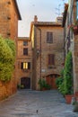 Pienza, Italy Ã¢â¬â May 27, 2017: Beautiful narrow street with sunlight and flowers in the village of Pienza, Italy Royalty Free Stock Photo